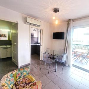 a living room with a table and a dining room at Agréable studio sur le port de Porto Vecchio in Porto-Vecchio