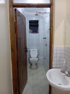 a bathroom with a toilet and a sink at Luxury 1BR - Traven Homes in Ruiru