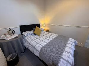 a small bedroom with a bed and a table at Spring Garden Guest House in Gosport