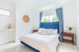 a bedroom with a bed with a blue headboard and a window at Beach Escape -Pool Patio -Free Parking -Pets in Villas del Mar
