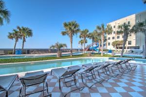 a group of chairs sitting next to a swimming pool at The Oasis at Orange Beach 1002 (Phoenix West II) in Orange Beach