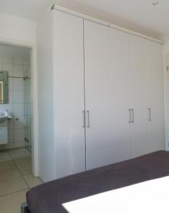 a white bedroom with white cabinets and a bathroom at Ferienwohnung "Il Paradiso" in Schluchsee mit Dachterrasse und Seeblick in Schluchsee +37 photos