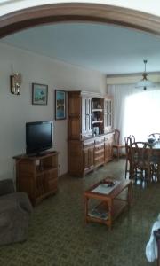 a living room with a television and a table at Hotel la Masia in Portbou