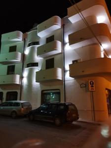 a black car parked in front of a building at Casa Blanca in Portopalo +11 photos