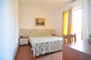 a bedroom with a bed and a table and a window at Casa Blanca in Portopalo