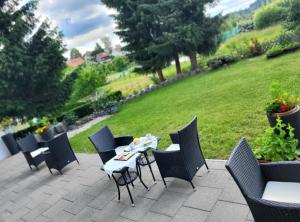 a table and chairs on a patio with a lawn at MorNight in Spiegelau