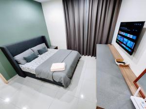 a bedroom with a bed and a flat screen tv at Kozi Square Twin Room with free Wi-fi & Carpark in Kuching