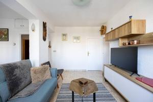 a living room with a blue couch and a flat screen tv at 2 Bdr Apt In Cornella 5 Mins Form The Metro in Cornellà de Llobregat