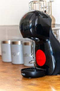 a black mixer sitting on top of a counter at 3 Bed Home - Sleeps 8 - Stoke City fc - Parking in Stoke on Trent