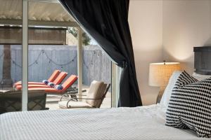 a bedroom with a bed and a chair on a balcony at The Palm House Tempe in Tempe +43 photos