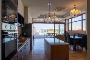 a kitchen with a table and a dining room at Luxury Villa Suzana in Hersonissos