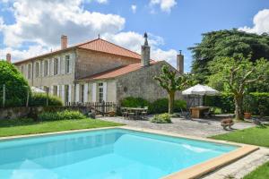 a swimming pool in front of a house at Domaine de Laguneaussan in Lesparre-Médoc