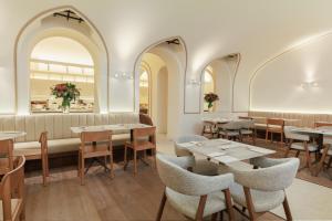ein Restaurant mit Tischen, Stühlen und einer Couch in der Unterkunft Hotel Medinaceli 4 Sup in Barcelona