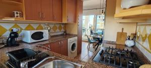 una cocina con fregadero y microondas en Charming Apartment with Pool in Puerto Rey 60 m², en Media Legua