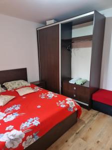 ein Schlafzimmer mit einem roten Bett und einem Spiegel in der Unterkunft Apartament Ireg in Galaţi