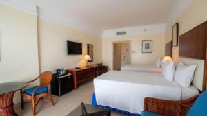 a hotel room with a large bed and a table at Edificio de Apartamentos Colón Miramar in Salinas