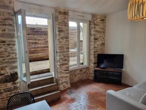 a living room with two windows and a television at Les terrasses de la moine in Cholet