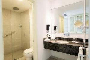a bathroom with a sink and a toilet and a mirror at Edificio de Apartamentos Colón Miramar in Salinas