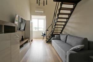 a living room with a couch and a spiral staircase at Luxury loft Cassia in Rome