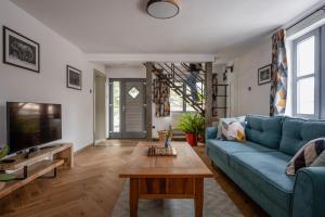 a living room with a blue couch and a coffee table at Mountain Air Lodge in Izvoru Mureşului