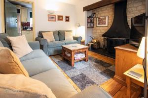 a living room with two couches and a fireplace at Mill Village 59, Millstream Cottage - P in Somerford Keynes
