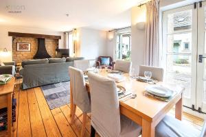 a dining room with a table and a couch at Mill Village 59, Millstream Cottage - P in Somerford Keynes