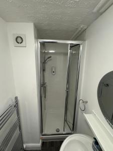 a bathroom with a shower and a toilet and a sink at Newstead En-suite Studios in Nottingham