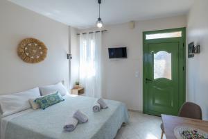 a bedroom with a green door and a bed with towels at Alex Downtown Studio in Argostoli