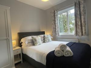 una camera da letto con un letto con due asciugamani sopra di Red Robin a Keswick