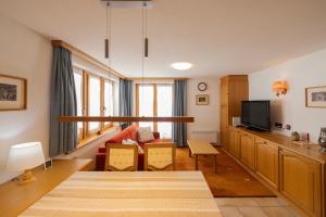uma sala de estar com um sofá e uma TV em Quiet corner with charm in Obergesteln em Obergesteln