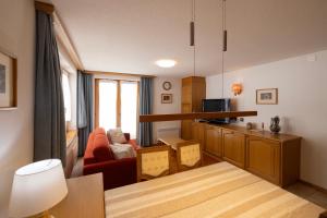 uma sala de estar com um sofá vermelho e uma cozinha em Quiet corner with charm in Obergesteln em Obergesteln