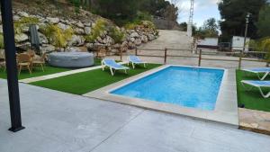 a swimming pool in a yard with chairs and a table at La Casona del Pinar Swiming Pool in Alhaurín de la Torre