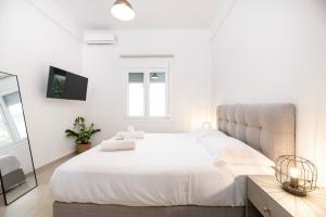 a white bedroom with a large bed and a mirror at Spacious & Luxe 3BR Downtown 1min to Beach in Kos