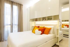 een slaapkamer met een wit bed met oranje en gele kussens bij Campus Bligny - Bocconi District in Milaan +14 foto's