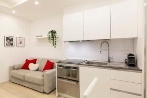 een woonkamer met een bank en een keuken bij Campus Bligny - Bocconi District in Milaan