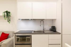een keuken met witte kasten en een spoelbak bij Campus Bligny - Bocconi District in Milaan