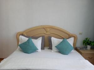 a bed with blue and white pillows on it at Звёздный Спутник in Aktobe
