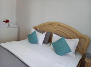 a bed with blue and white pillows on it at Звёздный Спутник in Aktobe