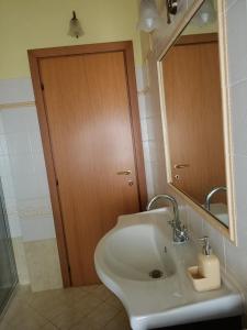 a bathroom with a sink and a wooden door at B&B Brunamonti in Arcevia