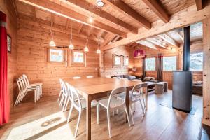 a dining room with a large wooden table and chairs at Chalet Les Amborzales in Taninges