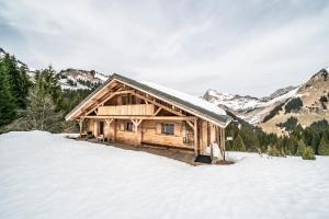 a log cabin in the snow in the mountains at Chalet Les Amborzales in Taninges