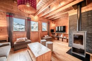 a living room with a fireplace and a tv at Chalet Les Amborzales in Taninges