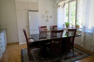 a kitchen with a dining room table and chairs at Knipnäs Läkarvillan in Ekenäs