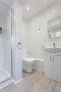 a bathroom with a toilet and a sink and a shower at Robins Perch, Bramhall in Bramhall