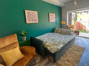 a bedroom with a bed and a chair at Modern Two Bed House With EV Off Road Parking in Henwick