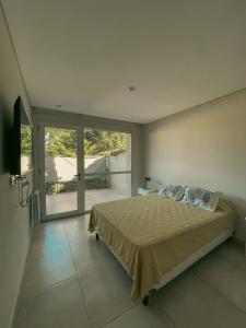 a bedroom with a bed and a large window at Luminoso y Aireado con Piscina in Saladillo