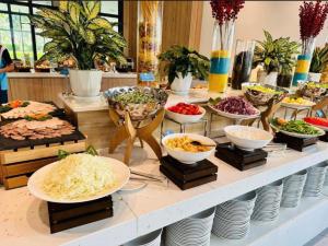un buffet avec des bols de nourriture sur une table dans l'établissement The M-Arena Cam Ranh BeachFont, à Thôn Hò Ða