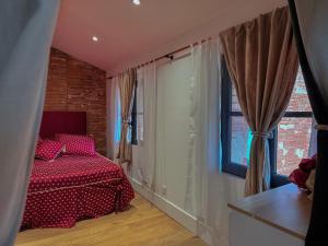 a bedroom with a red bed and a window at Le Loft Paradise in Montauban