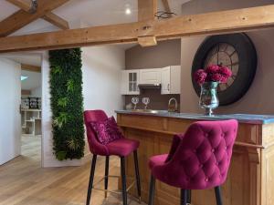 a kitchen with purple bar stools and a counter at Le Loft Paradise in Montauban