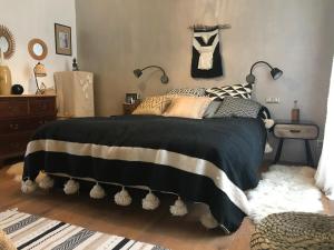 a bedroom with a bed with a black and white blanket at LE PRESBYTERE in Chasnay +49 photos